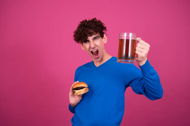 istock Diet and healthy lifestyle. Young attractive guy eats a burger. 1424664280