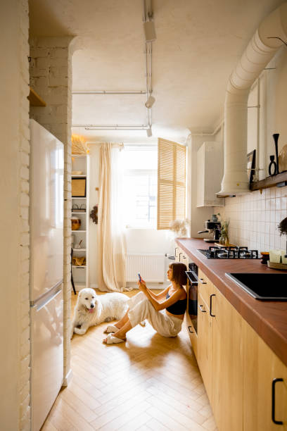 istock Woman with dog in modern and stylish kitchen 1424664363