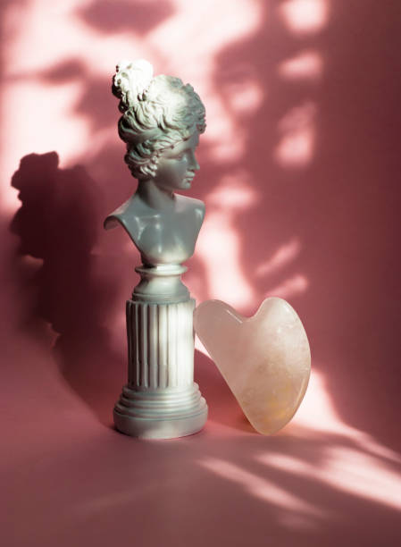 istock Gouache scraper for rose quartz massage on a pink background in sunlight. Anti-aging treatments. Facial care. 1424665736