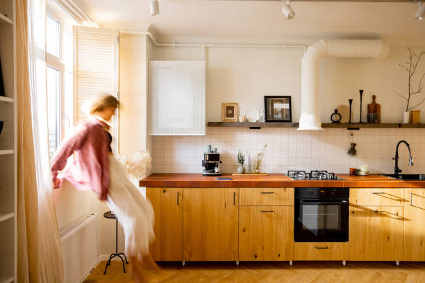 istock Modern kitchen interior with person sitting on window sill 1424665989