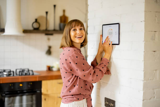 Woman use a digital tablet to control temperature in apartment