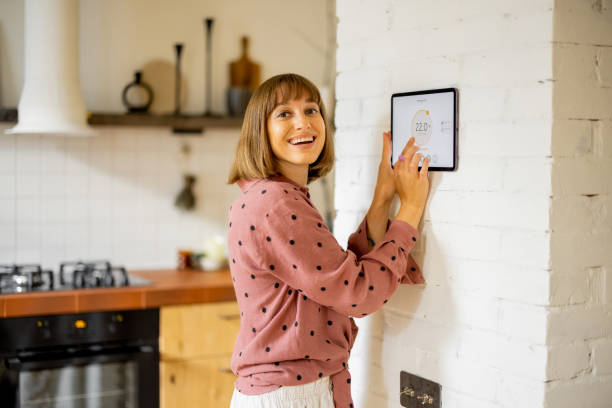 Woman use a digital tablet to control temperature in apartment stock photo