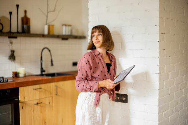 istock Woman use a digital tablet to control temperature in apartment 1424666532