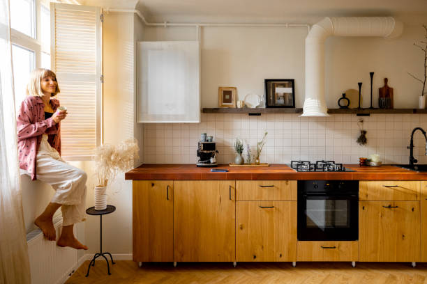 istock Modern kitchen interior with person sitting on window sill 1424668600