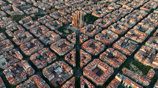 Aerial view of Barcelona city skyline and Sagrada Familia Cathedral at sunrise. Eixample residential famous urban grid. Cityscape with typical urban octagon blocks. Catalonia, Spain