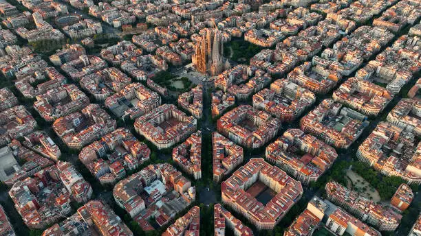 Photo of Aerial view of Barcelona city skyline and Sagrada Familia Cathedral at sunrise. Eixample residential famous urban grid. Cityscape with typical urban octagon blocks. Catalonia, Spain