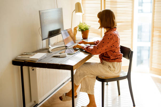istock Woman works online on computers at home 1424668833