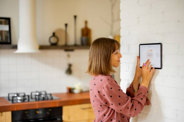 istock Woman use a digital tablet to control temperature in apartment 1424669197