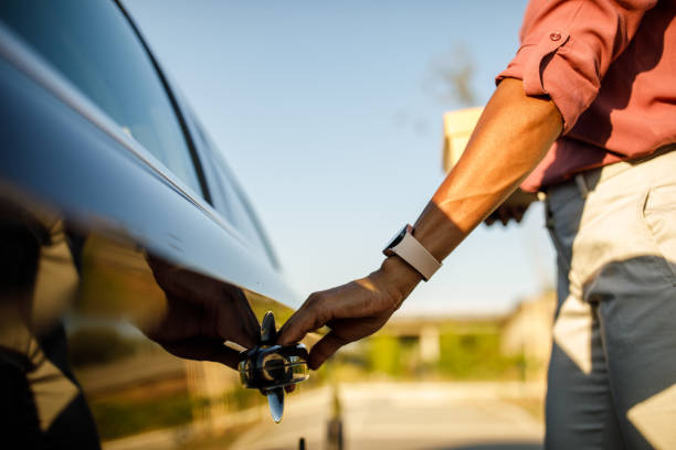 woman holding a handle on her car and opening the door - car car door green part of imagens e fotografias de stock