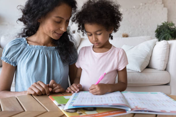 afrykańska mama pomaga uroczej córce z pracą domową w domu - teacher child preschool mathematics zdjęcia i obrazy z banku zdjęć