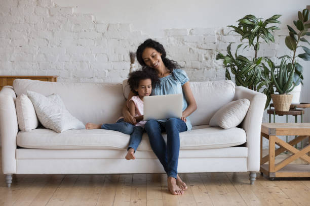 istock African woman and daughter spend leisure on internet using laptop 1424678294