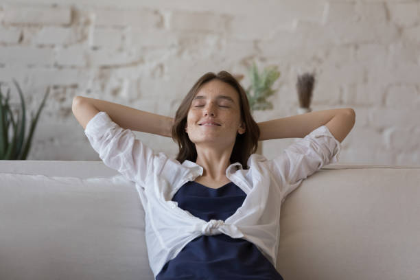 istock Calm 20s woman relaxing on cozy soft couch at home 1424679321