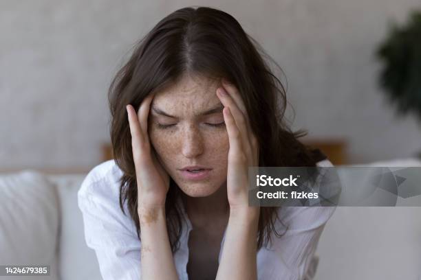 Freckled Woman Touches Temples Suffers From Headache Feels Unhealthy Closeup Stock Photo - Download Image Now