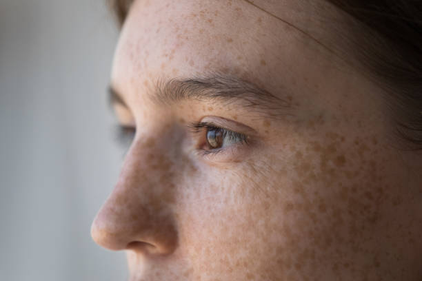 Side view face of freckled serious pensive woman staring aside Side profile view face of freckled serious pensive woman staring aside. Close up cropped image of thoughtful young 18s female looking into distance. Concept of vision care, eyesight check up in clinic side eye expression stock pictures, royalty-free photos & images