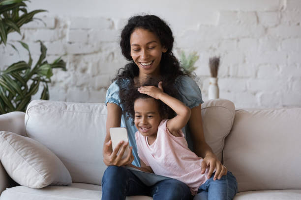 istock African mom and daughter have fun holding smartphone use application 1424679823
