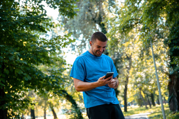 istock Cheerful Man with earphones using smartphone 1424680586