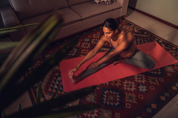 istock Expectant mother doing yoga on exercise mat at home 1424684522