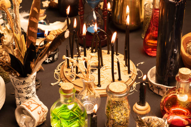 istock Witchcraft still life with black burning candles selective focus. Esoteric gothic and occult witch table for Halloween. Various magic objects and ritual arrangement. Gothic Halloween. 1424685569