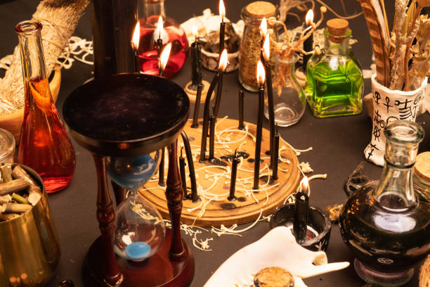 istock Witchcraft still life with black burning candles selective focus. Esoteric gothic and occult witch table for Halloween. Various magic objects and ritual arrangement. Gothic Halloween. 1424685572