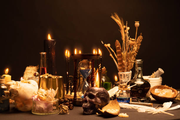 istock Selective focus on human skull candle. Occult and esoteric witch doctor still life. Halloween with magic objects. Black candle, crystal stones, teeth potions bottles on witch table. Mystic witchery. 1424685591