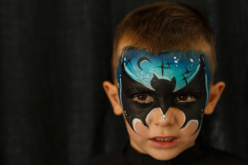 Headshot of a boy with face paint, Halloween costume.