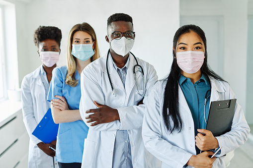 Portrait of a group of happy doctors and nurses wearing masks of diversity race in hospital