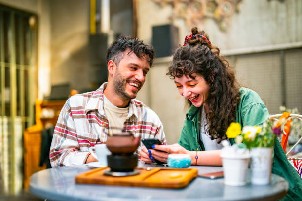 istock Young couple using mobile phone at the cafe 1424690501