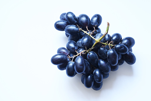 Black grapes on white background