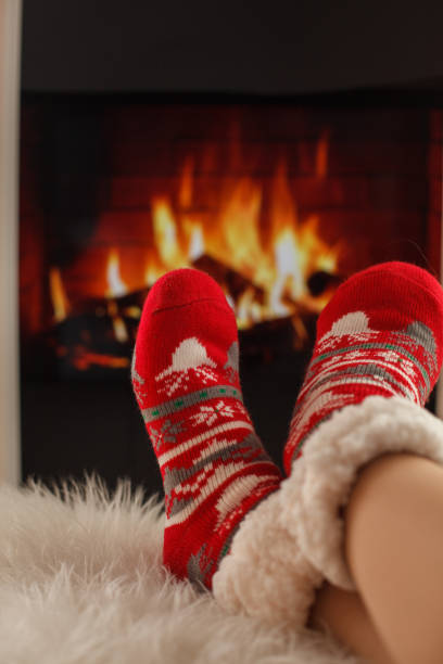 istock Warming her feet by the fireplace while wearing cozy Christmas themed socks 1424692017