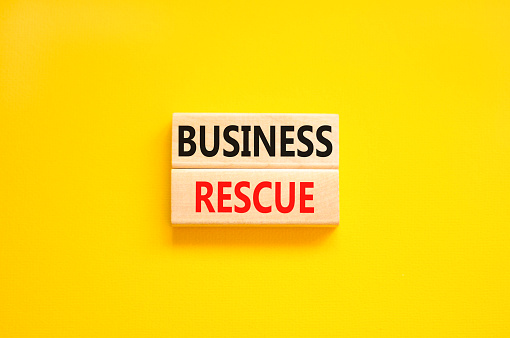 Business rescue symbol. Concept words Business rescue on wooden blocks on a beautiful yellow table yellow background. Business rescue and support concept. Copy space.