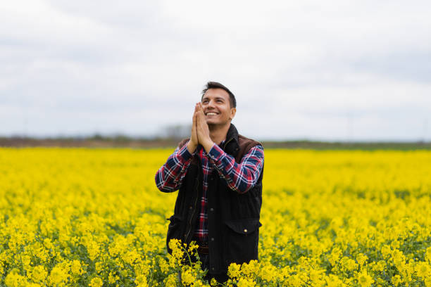 istock Young Middle Eastern farmer praying in a rapeseed yellow field 1424710807