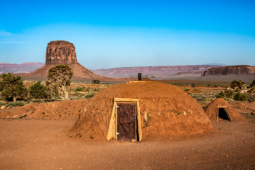 The hogan is the traditional home for the Navajo people who practice traditional religion.  They were originally made from wooden poles, tree bark, and mud and were round or cone shaped. The opening faces east to capture the early sun and for good blessings. 
Monument Valley, AZ, USA
05/22/2022