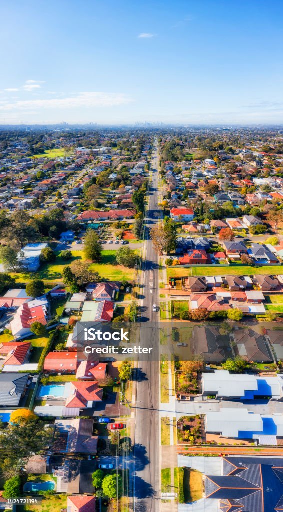 D Ryde QUarry St 2 CBD Vert pan Local traffic residential street in City of Ryde - vertical aerial panorama towards distant Sydney city CBD skyline. Residential Building Stock Photo