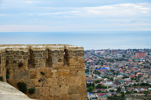 Defence wall of the Naryn-Kala fortress, Caspian sea and modern city on background. Derbent. Republic of Dagestan Russia
