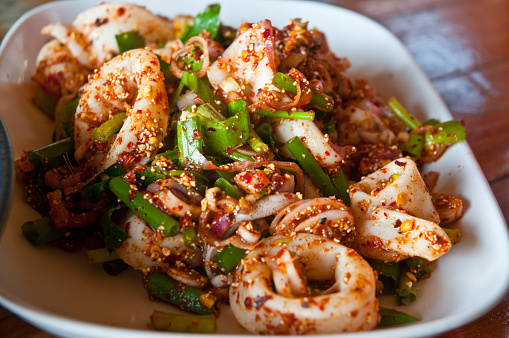 Thai style spicy chili squid salad on white dish