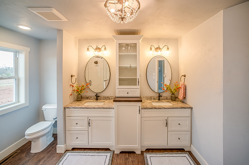 Beautifully decorated bathroom with floor mats and oval shaped mirrors