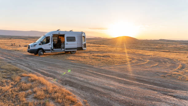 istock Camper van in a desert field at sunset with lens flare 1424732945