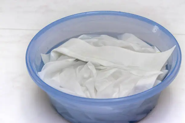 White clothes soaked in water in a basin