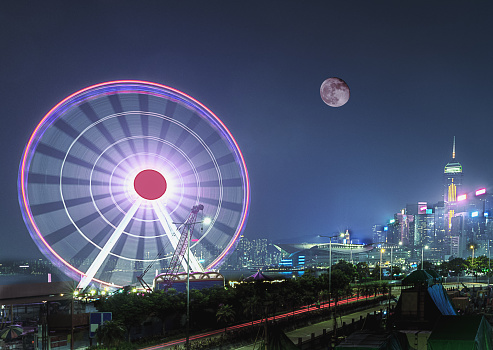 The moon hangs on the Ferris wheel at central