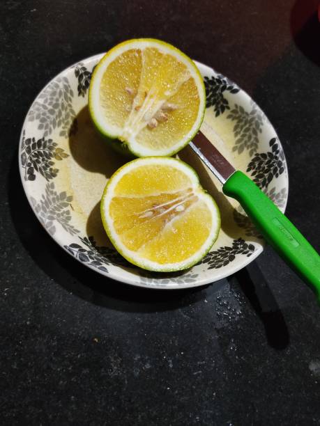 istock Cut a lemon in half on a plate,Cut a lemon and knife,lemon,Knife and plate 1424760978
