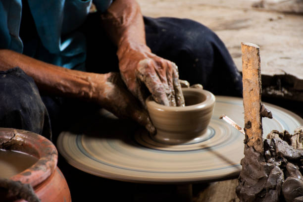 istock Thai craftsmanship technician or professional potter use machine working sculpture handmade pottery and handicraft earthenware for show sale at Koh Kret island in Pak Kret city at Nonthaburi, Thailand 1424768993
