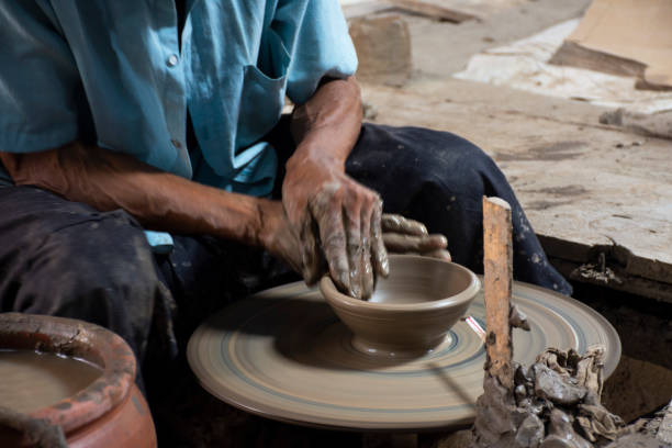 istock Thai craftsmanship technician or professional potter use machine working sculpture handmade pottery and handicraft earthenware for show sale at Koh Kret island in Pak Kret city at Nonthaburi, Thailand 1424769064