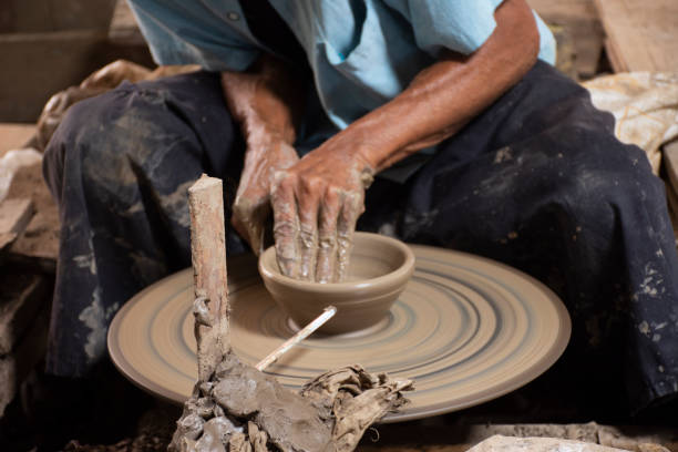 istock Thai craftsmanship technician or professional potter use machine working sculpture handmade pottery and handicraft earthenware for show sale at Koh Kret island in Pak Kret city at Nonthaburi, Thailand 1424769121