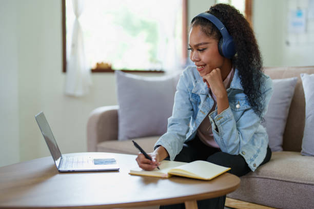 istock African American using a notebook and computer to study online at home 1424785084