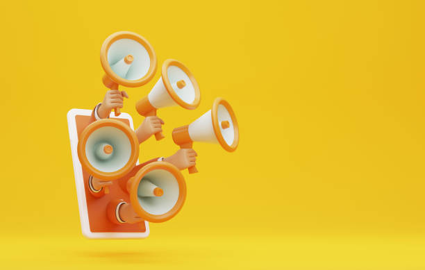 istock Several hands holding megaphones on smartphones in yellow background. 1424790180