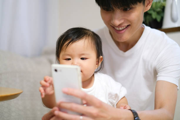 istock Father showing smart phone to baby 1424791670