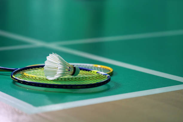 istock Shuttlecock with badminton rackets on court 1424803609
