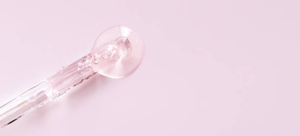 istock glass pipette serum closeup on a light pink background 1424810733