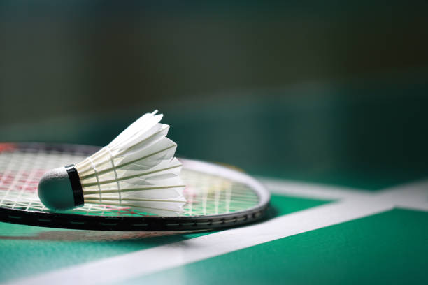 istock Shuttlecock with badminton racket on court 1424812617