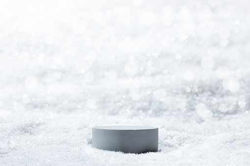 Gray podium with snow background to show cosmetic products. White color minimal backdrop with stand for branding and presentation.